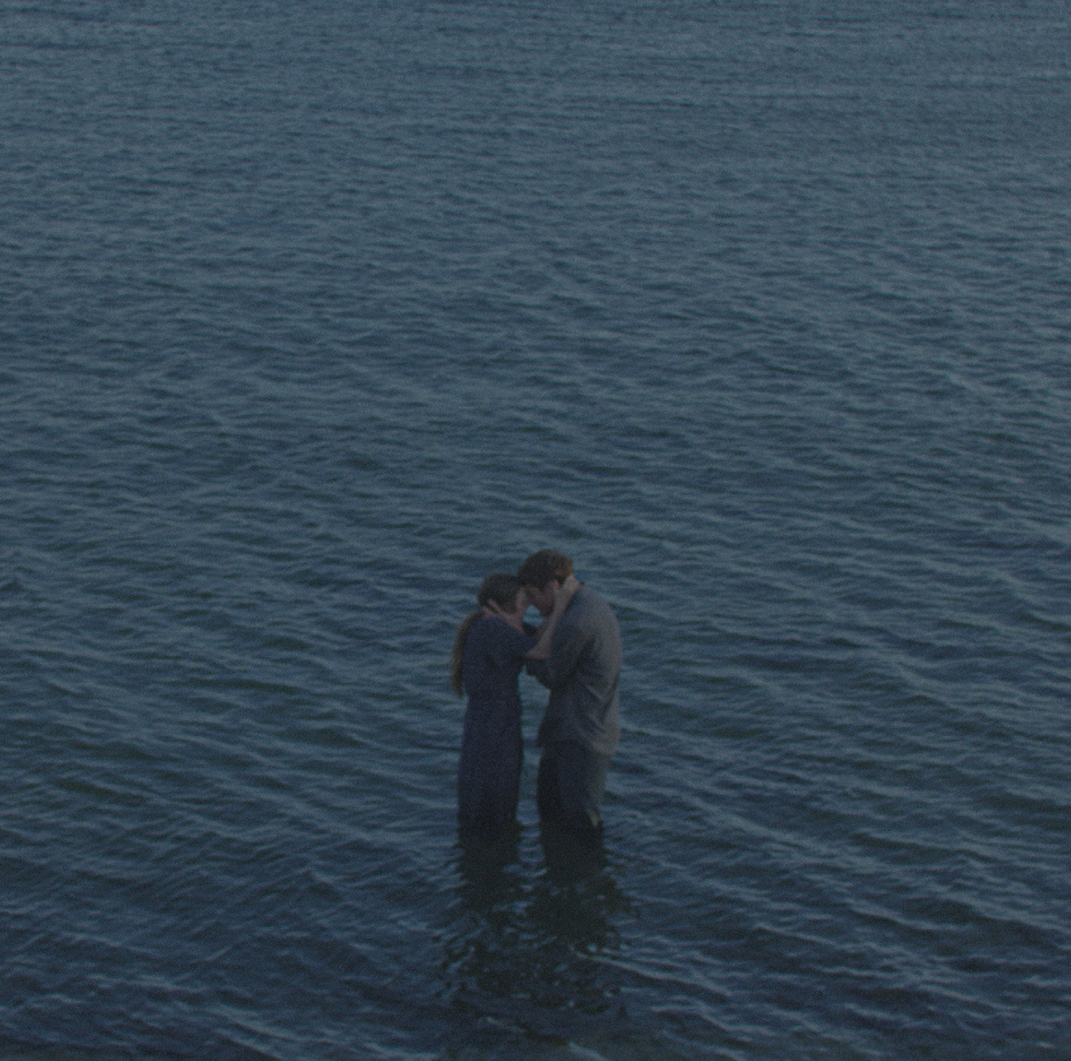 Two figures standing together in the sea